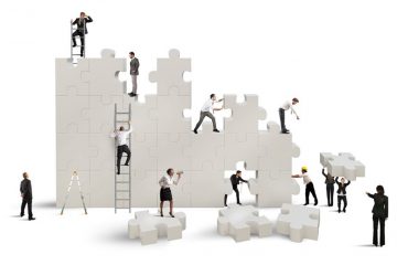 businesspeople-assembling-puzzle-Debbie-Ruston